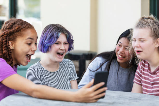 istock Four tween girls looking at smart phone, laughing 1312018702