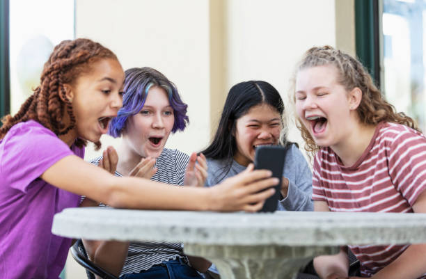 istock Four tween girls looking at smart phone, laughing 1312018706