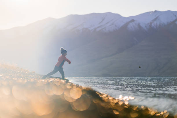 Kid throwing pebbles in lake Ohau, Canterbury, South Island, New Zealand.
