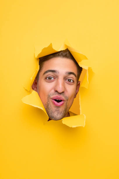 istock Surprised man peeking from hole 1312022118