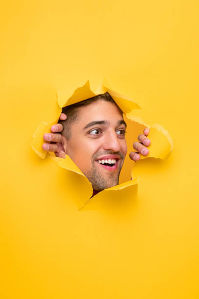 istock Amazed man tearing yellow paper 1312022123