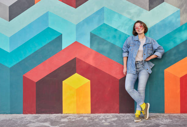 istock Cheerful young woman leaning on colorful wall 1312022164