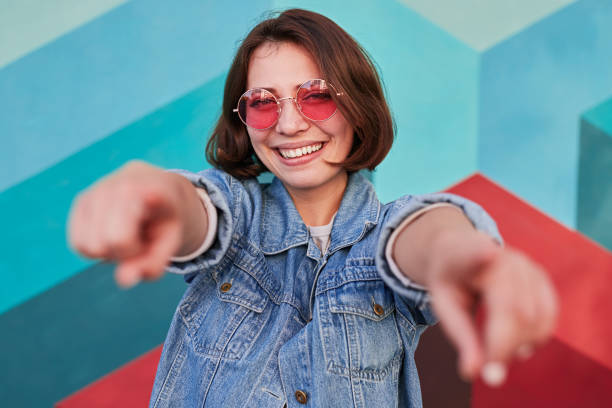istock Cheerful young woman pointing at camera 1312022166