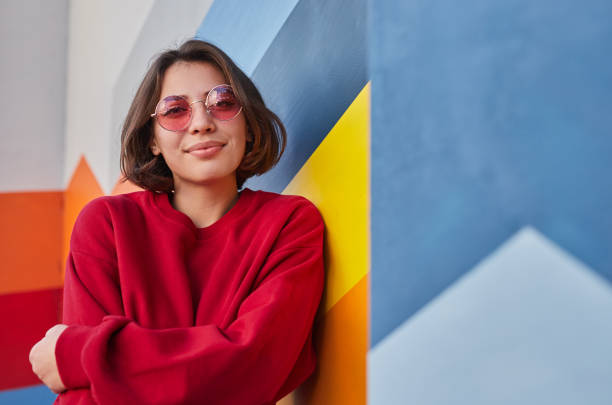 istock Positive female hipster leaning on colorful wall 1312022171
