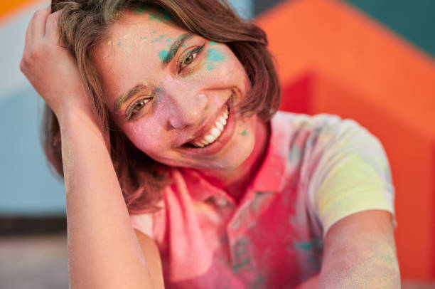 istock Optimistic young female having fun on paint festival 1312022192