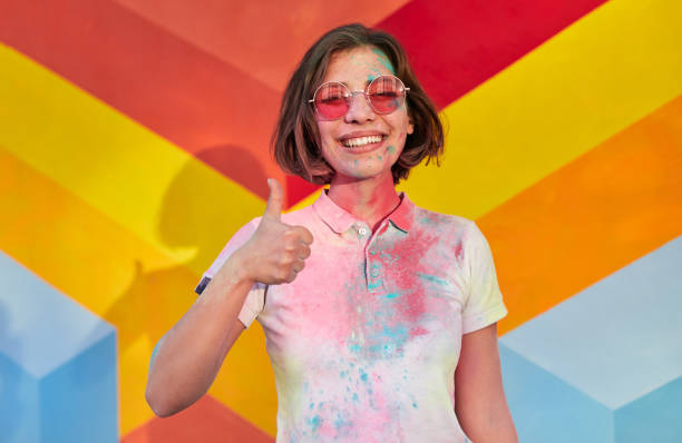 istock Happy young female covered with paint gesturing thumb up 1312022201