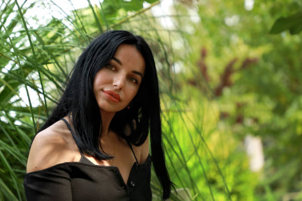 istock Beautiful young woman sitting on park bench 1312033499