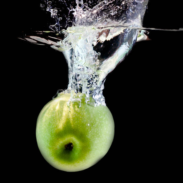 istock one ripe green apple fell into the water 1312033714