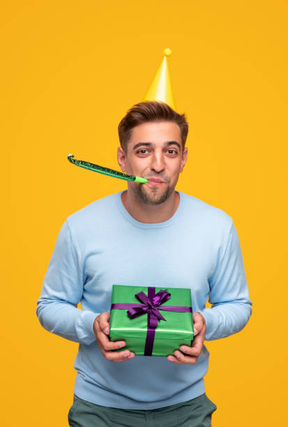 istock Cheerful man with party accessories and gift box 1312035172