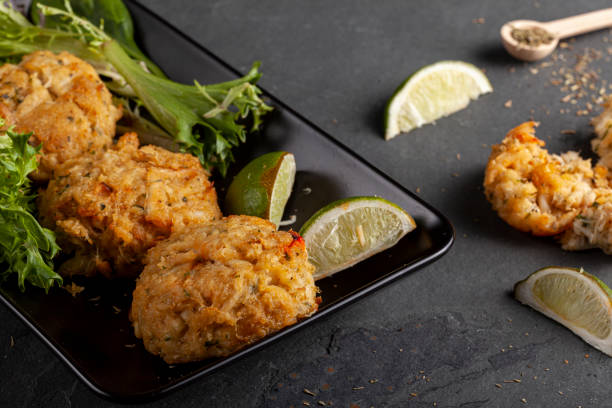 famous maryland crab cakes with side dishes and dipping sauce made with blue crab caught in Chesapeake bay, Crab cake is a favorite dish in the state of Maryland. Meat is mixed with sauces, crumbles, seasoning and vegetables and shaped in to patties to grill maryland state colors stock pictures, royalty-free photos & images