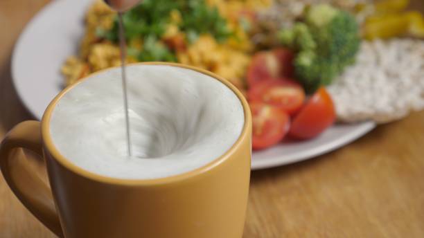 vue supérieure de verser le thé de matcha dans le lait à base de plante mousseuse. petit déjeuner végétalien sain - foamed milk photos et images de collection