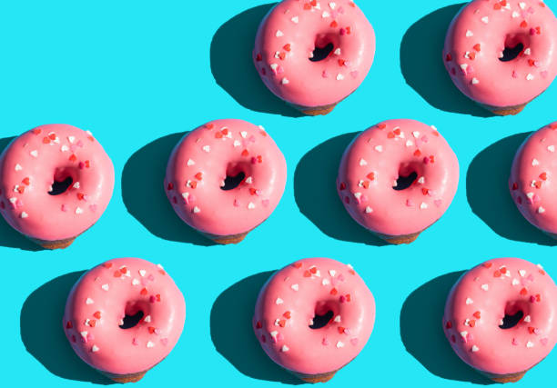 istock Trendy sunlight. Summer pattern made with pink doughnut on bright light blue turquoise background. Minimal summer concept. Pop art style. Donut 1312057064