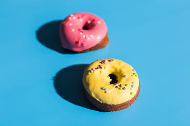 istock Trendy sunlight. Summer doughnuts on bright light blue turquoise background. Minimal summer concept. Pop art style. Donut 1312057088