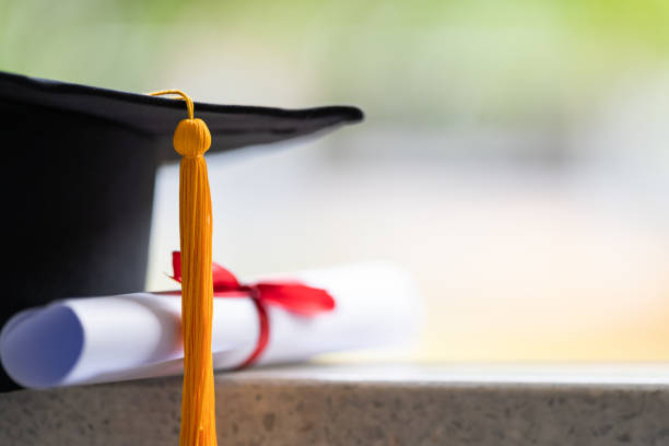 Close-up of a mortarboard and degree certificate put on the table. Education stock photo Close-up of a mortarboard and degree certificate put on the table. Education stock photo college stock pictures, royalty-free photos & images