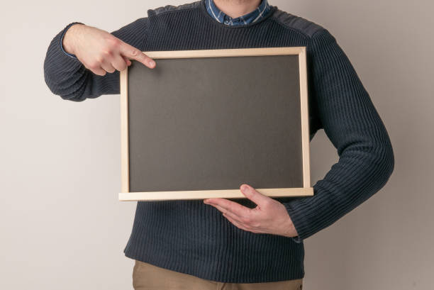 istock beautiful man pointing on blank chalk blackboard on white background 1312058236
