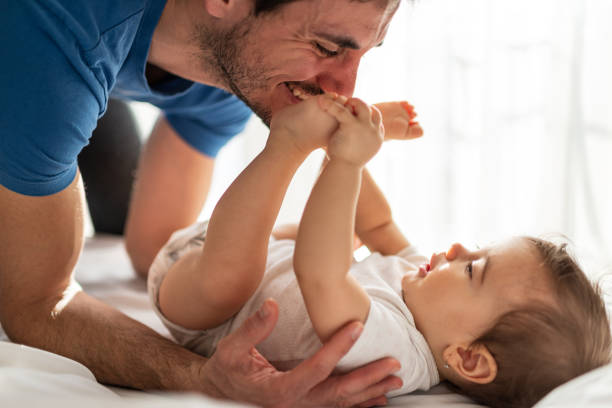 istock Father and baby playing on bed 1312058366