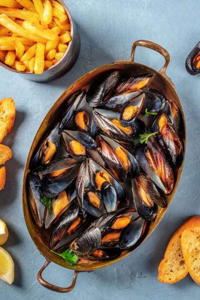 Moules frites, Belgian mussels with French fries Moules frites, Belgian mussels with French fries, shot from above moules frites stock pictures, royalty-free photos & images