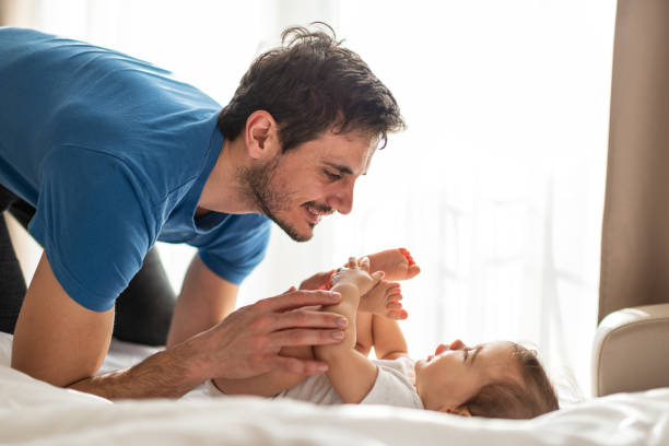istock Father and baby playing on bed 1312058415