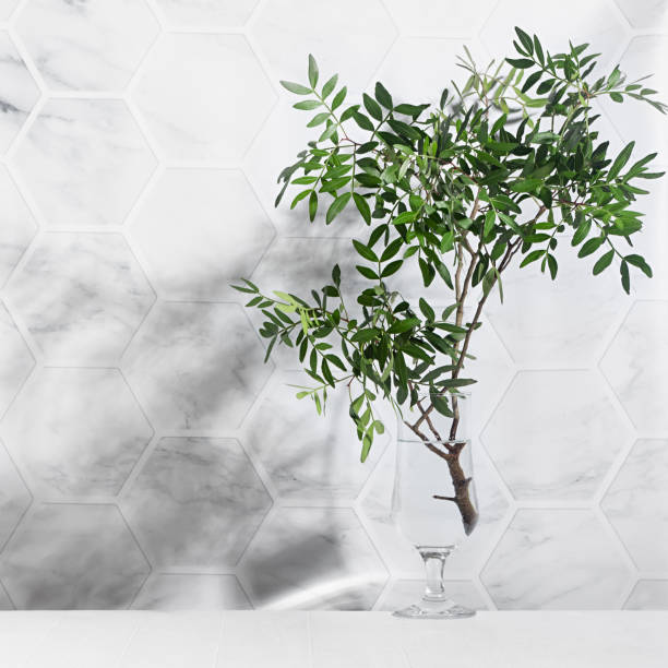 istock Sunny summer green leaves as bouquet with shadow on marble tile wall, wood table in sunlight, square. 1312058701