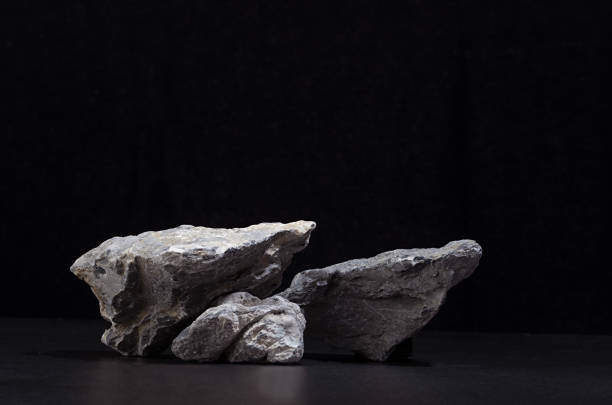 istock Rough natural grey stone as podium for packaging and cosmetic presentation on black background, copy space. 1312059477