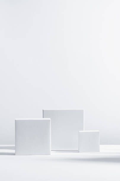 elegancki nowoczesny geometryczny styl prezentacji na wyświetlaczu produktów kosmetycznych - białe kwadratowe podium w słońcu z cieniem w białym tle, pionowym. - box white cube blank zdjęcia i obrazy z banku zdjęć