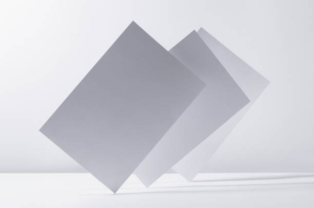 istock Abstract white grey minimalist background with flying papers in light with shadow as blank copy space. 1312060891
