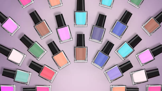 Bottles of colourful nail polish on purple background. Nail polish bottles in a circular formation from top view. Copy space available. Bottles of colourful nail polish on purple background. Nail polish bottles in a circular formation from top view. Copy space available. nail salon stock pictures, royalty-free photos & images