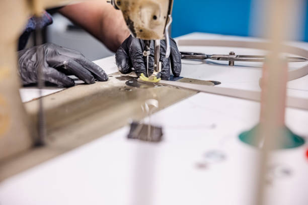istock Using protective gloves and sewing on machine in repair shop 1312064237