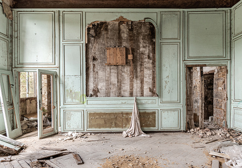 Room in a ruined empty castle with a pastel green wall