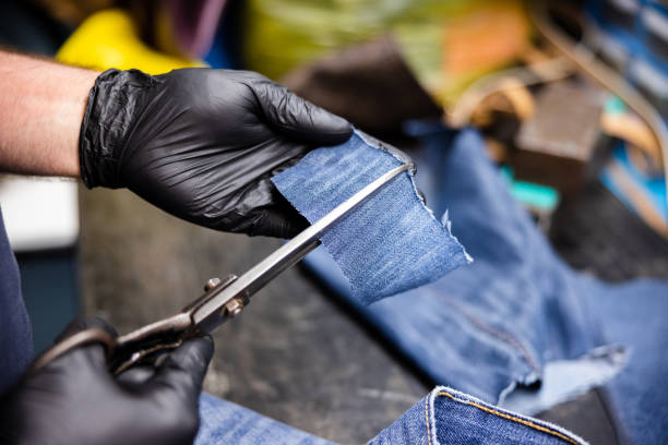istock Cutting a piece of denim with scissors for patching 1312064444