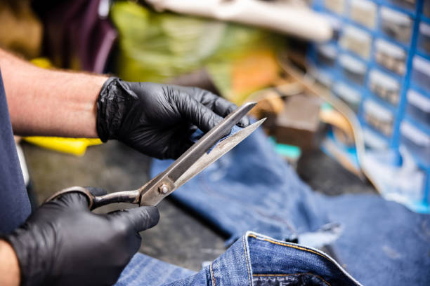 istock Cutting a patch of jeans with scissors for repairs 1312064993