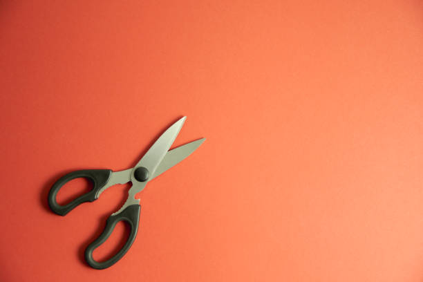 Scissors cut a red background with cardboard tehsturoy