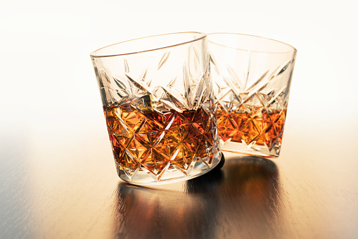 alcoholic drink, whiskey in glasses on brown wooden background