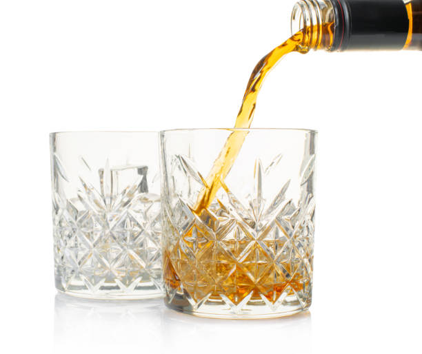 whiskey is poured into a glass from bottle - brandy bottle alcohol studio shot imagens e fotografias de stock