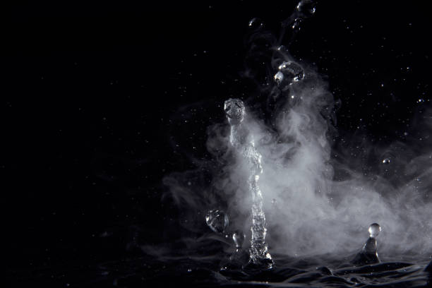 Boiling water splash with steam on black background closeup Boiling water splash with steam on black background closeup. fog transparent stock pictures, royalty-free photos & images