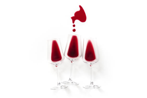 Red wine in glasses, overhead flat lay shot on a white background with a wine stain