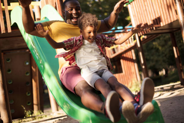 istock African American dad playing with son on playground. 1312067246