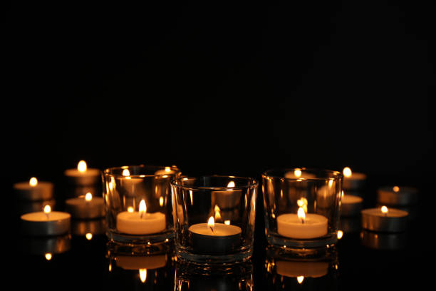 istock Burning candles in glass holders on table against dark background, space for text 1312068169
