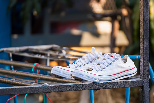 White sneakers on clothesline to dry in the sun.