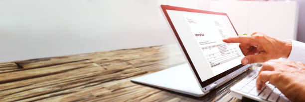istock Businessman's Hands Working On Invoice On Laptop 1312071033