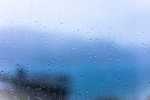 istock Raindrops on window glass with blur background 1312072239