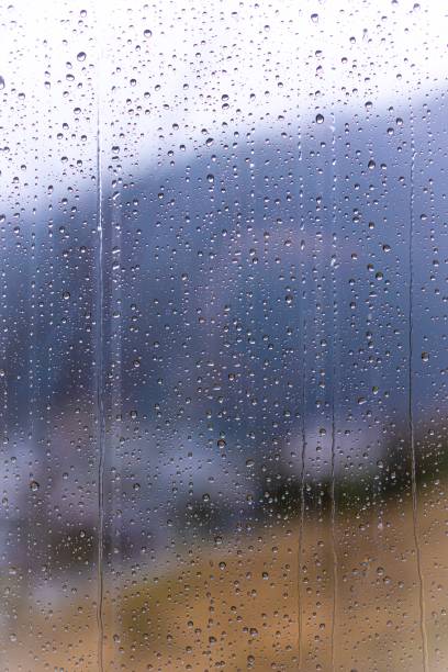 istock Raindrops on window glass with blur background 1312072272