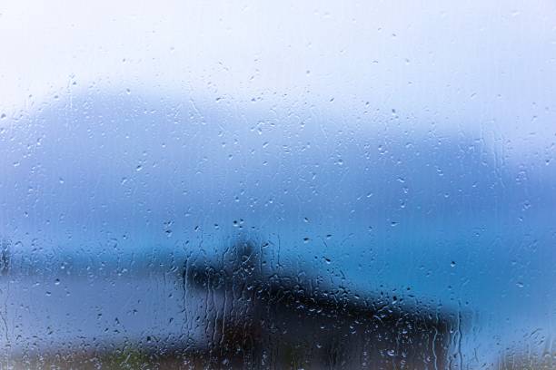 Raindrops on window glass with blur background