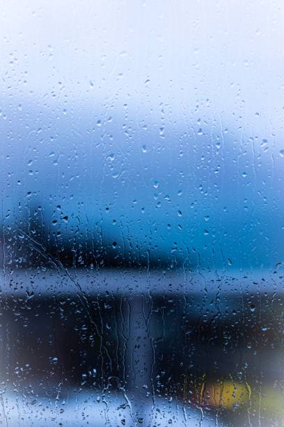 istock Raindrops on window glass with blur background 1312072337
