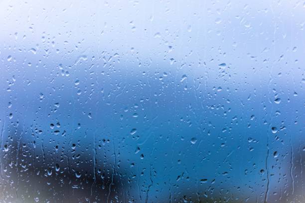 istock Raindrops on window glass with blur background 1312072369