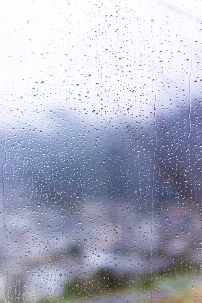 istock Raindrops on window glass with blur background 1312072387