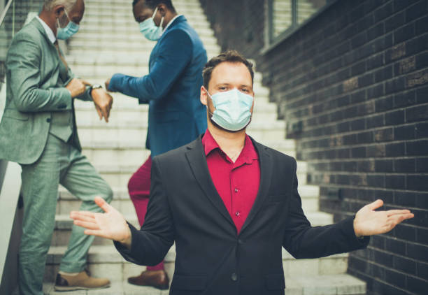 Small Group of business men with protective mask o face. Focus is on foreground.