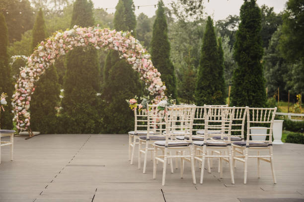 istock wedding ceremony in a restaurant garden: floral arch and rows white chairs 1312072628