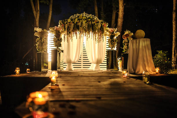istock arch decorated with flower compositions and curtains at night; a path with candles that goest to it 1312073490