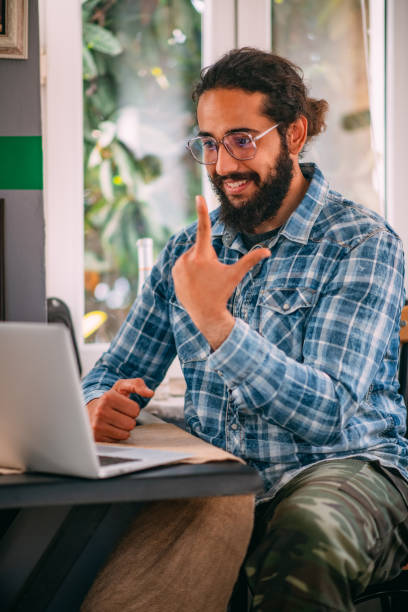 istock Young Man Having a Video Call With Sign Language on Laptop 1312076103